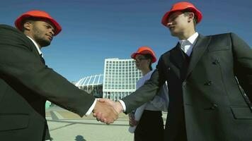 Three confident business architect standing on the site and view the object video