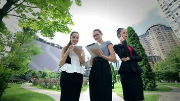 Three successful business woman working on the tablet take calls video