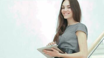 Young attractive businesswoman with the tablet smiling video