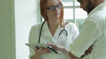 Doctor of the window shows the patient test results on the tablet video