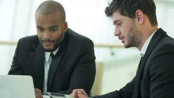 Smiling successful businessmen sitting at table in office video