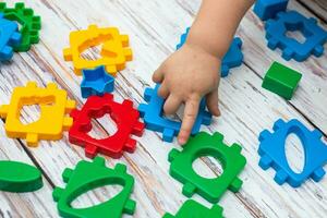 mano de niño poniendo verde acción figura en bebé bloques forma clasificador juguete. educativo clasificación pareo juguete para niños pequeños foto