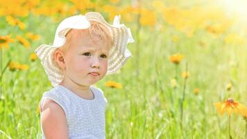 Portrait of beautiful little girl on background of yellow flowers in a meadow. happy childhood in nature. Walking while quarantine away from people photo