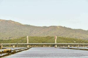 a bridge over a body of water with mountains in the background photo