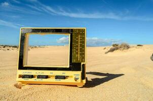 a yellow tv on the sand photo