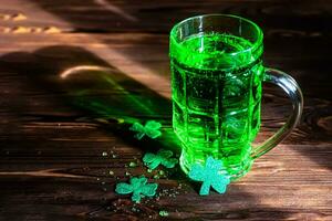 St Partick's day concept. Alcoholic green beer in the glasses and clover leaves photo