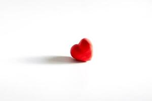 Red heart of rumpled paper on a white background with shadow. Valentine's Day Concept. A symbol of separation, sadness photo