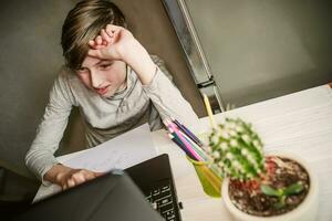 en línea curso estudiante adolescente chico utilizando ordenador portátil con interesar a hogar. distancia cursos de creatividad y multa letras para adolescentes y joven personas foto