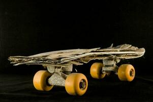 a skateboard made out of wood and yellow wheels photo