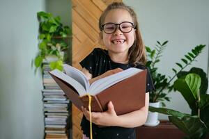 A school-age girl wearing glasses with books in hands. photo