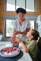 Grandmother and granddaughter preparing meatballs. photo