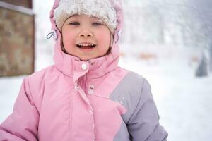 un niña en invierno ropa soportes en el calle. foto