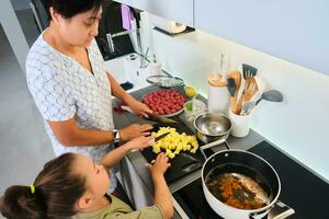 Grandmother and granddaughter are preparing soup. photo
