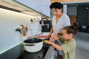 abuela y nieta son preparando sopa. foto