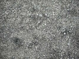 Above view of concrete surface is plastered on the road surface with many rocks mixed in on the ground. For background and textured. photo