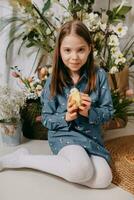 Two girls in a beautiful Easter photo zone with flowers, eggs, chickens and Easter bunnies. Happy Easter holiday.