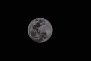 the moon is seen in the dark sky photo