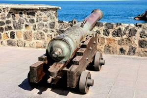 a cannon on display in front of a stone wall photo