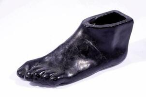 a black foot shaped vase with a foot on it photo