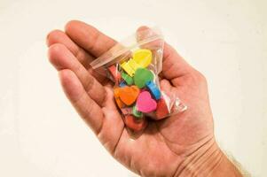 a hand holding a bag of colorful hearts photo