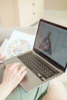 Tver, Russia-august 7, 2022. A woman with a laptop is studying human design. The concept of studying esoteric sciences. Studying rave postcards from human design photo