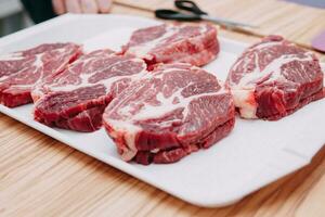 Aged beef for cooking steak in a cooking class. Raw beef and greens, close-up. photo