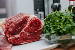 Aged beef for cooking steak in a cooking class. Raw beef and greens, close-up. photo