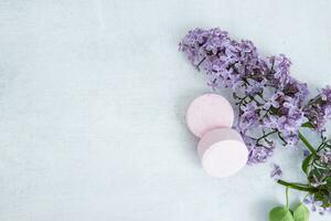 Concept of Spa-cosmetic and cosmetic procedures. Bath salt in effervescent tablets with lilac flowers on light concrete background. The concept of a waste-free lifestyle. Space for text. photo