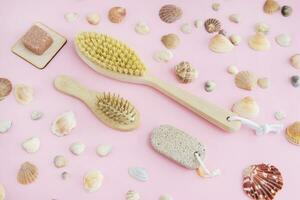 Concept of Spa-cosmetic and cosmetic procedures. Spa-sea salt, wooden comb, massager, anti-cellulite massage brush on a pink background. The concept of a waste-free lifestyle. photo