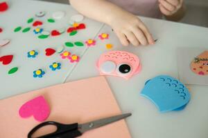 A blogger girl makes a felt craft for Valentine's Day in the shape of a heart. The concept of children's creativity and handmade. photo