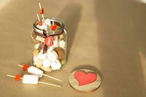 sweet gift for Valentine's Day with your own hands. A gift for the holiday made of heart-shaped candies and marshmallows photo