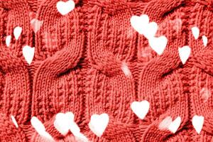 Beautiful handmade knitted repeating pattern. Festive bokeh background in the form of hearts for Valentine's Day photo