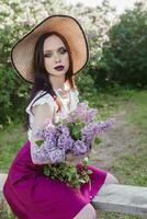 A fashionable girl with dark hair, a spring portrait in lilac tones in summer. Bright professional makeup. photo