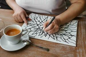 TVER, RUSSIA - FEBRUARY 25, 2023. Woman draws neurographics at table at a psychological session, neurographic pencil drawing to remove restrictions, art therapy photo