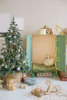 The interior of a children's room decorated for the Christmas holidays. A Christmas tree with garlands and a children's wardrobe with soft pillows. photo