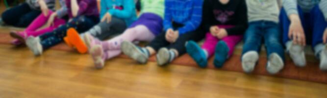 Children sit, who stretched his legs, who cross-legged on the fl photo