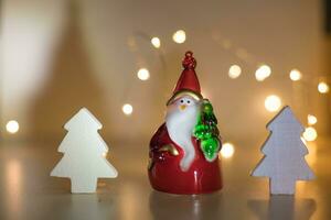 Santa Claus with a Christmas tree on the background of garland lights. Christmas background. Christmas background with bokeh from garlands. photo