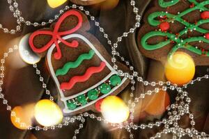 Banner for Christmas and New Year gingerbread. Christmas trees, toys, snowmen, garlands on a background of brown silk fabric. Bright bokeh. photo