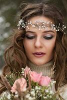 hermosa novia en un blanco vestir con un ramo de flores en un cubierto de nieve invierno bosque. retrato de el novia en naturaleza foto