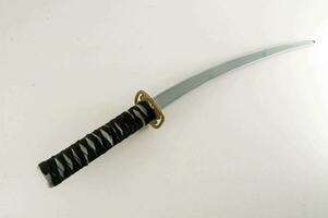 a samurai sword with a black handle and gold trim photo