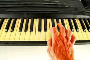 a hand is touching the keys of a piano photo