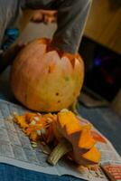 Child carves from a pumpkin. family fun activity. arved pumpkins into jack-o-lanterns for halloween. photo