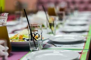 Serving table in the children's cafe. Plates and glasses on a ta photo