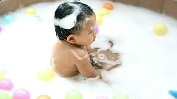 Kids playing in the pool. Baby Playing Multicolor Ball In The Little Pool. video