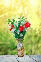 Still life of bird cherry and tulips. bouquet flowers on background of green grass. Background for greeting card with beginning of spring, March 8 or Valentine's Day. photo