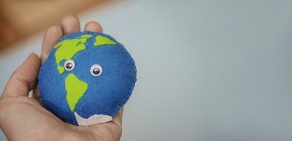 earth in woman's hand. homemade toy made of felt with oceans and land. Save the planet. World ocean day, saving water campaign. Cosept Earth Day. photo