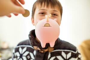 Child with a piggy bank near the face. Money hole in the back of a pig photo
