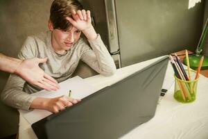 The father's hand indicates errors in learning. The boy does assignments from an online school. Online learning. Back to school photo