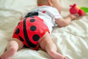 un niño de 2 meses gatea en el cama a el primero juguete. estímulo de gateando enseñando un niño arriba a seis meses. foto