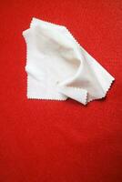 brightly colored cloth that serves to wipe glasses, on a red background photo
